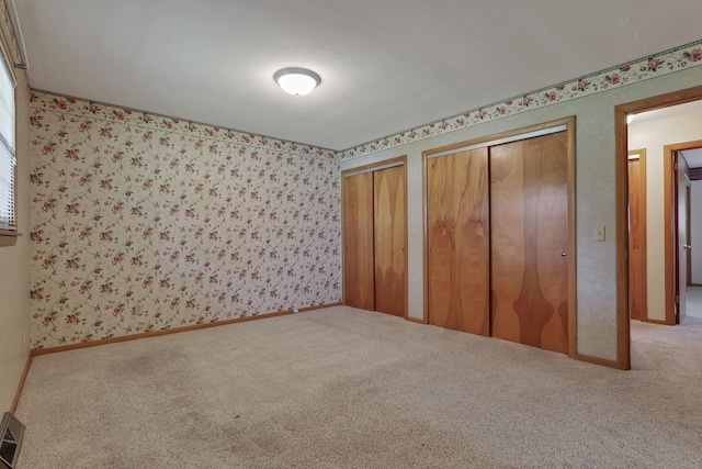 19 Kirby Rd, Heath, OH 43056 - unfurnished bedroom with carpet, two closets, and wallpapered walls