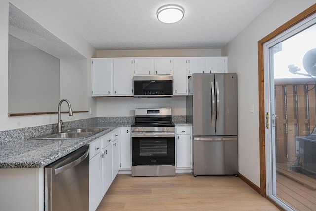 7599 Worth Galena Rd Unit 38, Worthington, OH 43085 - kitchen with stainless steel appliances, white cabinetry, light wood finished floors, and light stone countertops