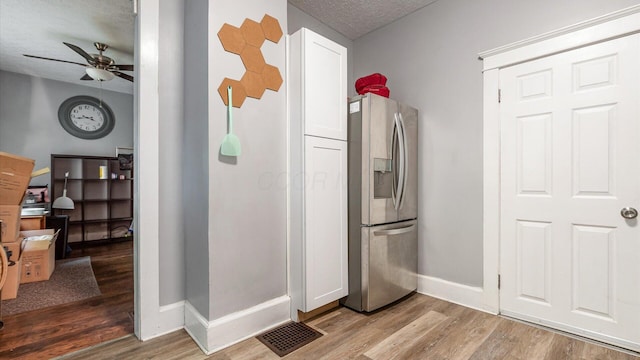 467 Mount Vernon Rd, Newark, OH 43055 - kitchen featuring stainless steel fridge, a ceiling fan, light wood-type flooring, a textured ceiling, and white cabinets