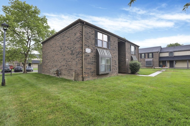 5781 Hallridge Cir Unit B, Columbus, OH 43232 - view of home's exterior featuring brick siding and a yard