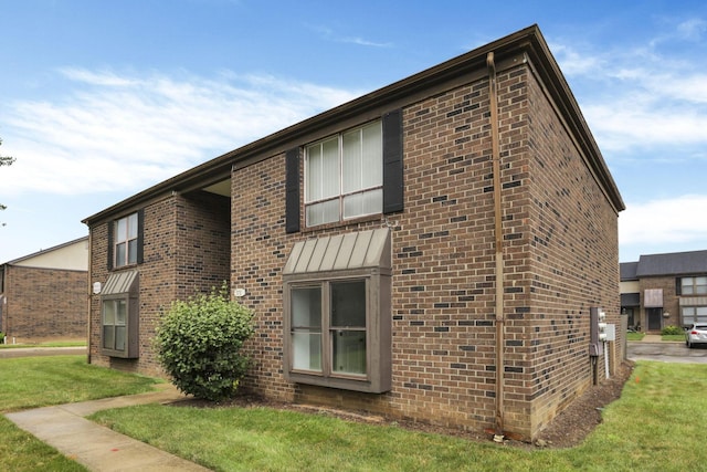 5781 Hallridge Cir Unit B, Columbus, OH 43232 - view of property exterior featuring brick siding, a yard, and a standing seam roof