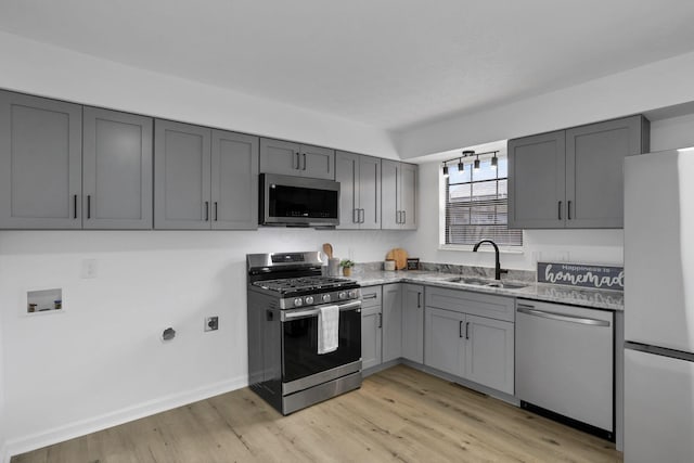 5781 Hallridge Cir Unit B, Columbus, OH 43232 - kitchen featuring stainless steel appliances, gray cabinets, light stone counters, and light wood-style flooring