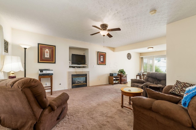 7787 Freesia St Unit 216, Blacklick, OH 43004 - living room featuring ceiling fan, carpet, a tiled fireplace, and a textured ceiling