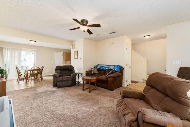 7787 Freesia St Unit 216, Blacklick, OH 43004 - living room featuring a ceiling fan, light colored carpet, a textured ceiling, and stairs