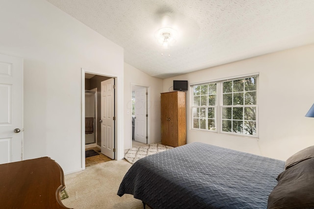 7787 Freesia St Unit 216, Blacklick, OH 43004 - bedroom with light colored carpet, lofted ceiling, a textured ceiling, and ensuite bath