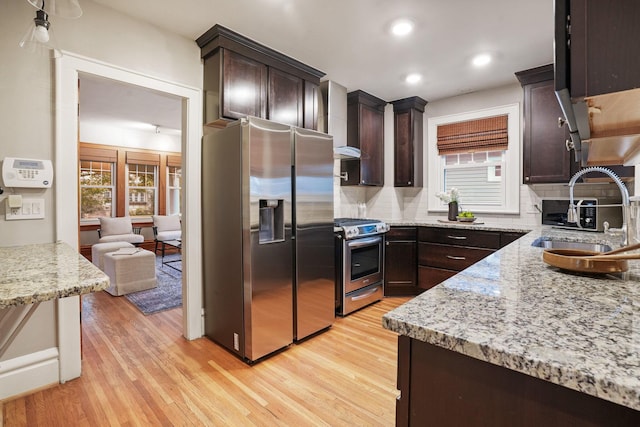 41 Northmoor Pl, Columbus, OH 43214 - kitchen with appliances with stainless steel finishes, dark brown cabinetry, decorative backsplash, light wood finished floors, and light stone counters