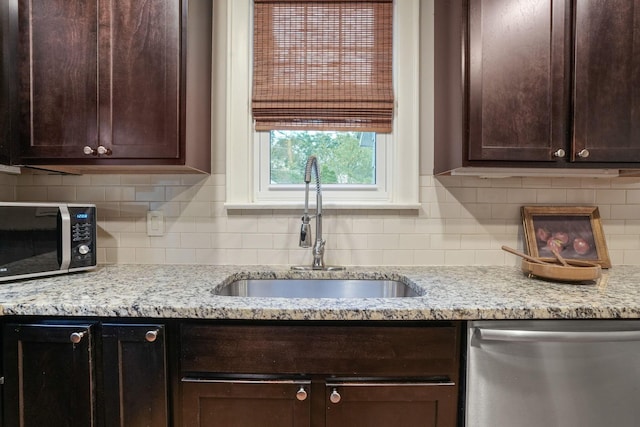 41 Northmoor Pl, Columbus, OH 43214 - kitchen with stainless steel appliances, dark brown cabinetry, tasteful backsplash, and light stone countertops