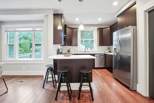 1867 Bryden Rd, Columbus, OH 43205 - kitchen with stainless steel appliances, dark brown cabinets, a peninsula, light countertops, and healthy amount of natural light