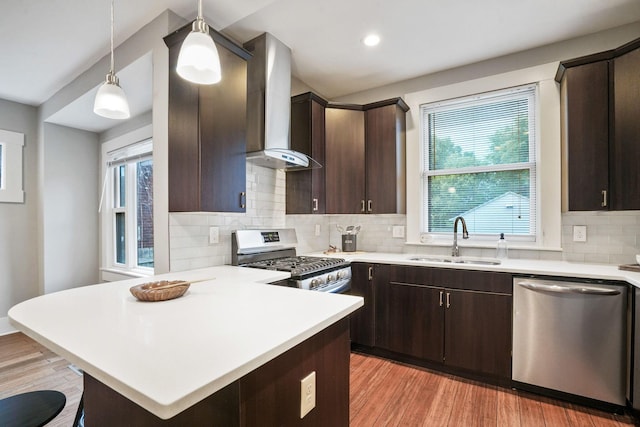 1867 Bryden Rd, Columbus, OH 43205 - kitchen with appliances with stainless steel finishes, wall chimney range hood, dark brown cabinets, light countertops, and tasteful backsplash
