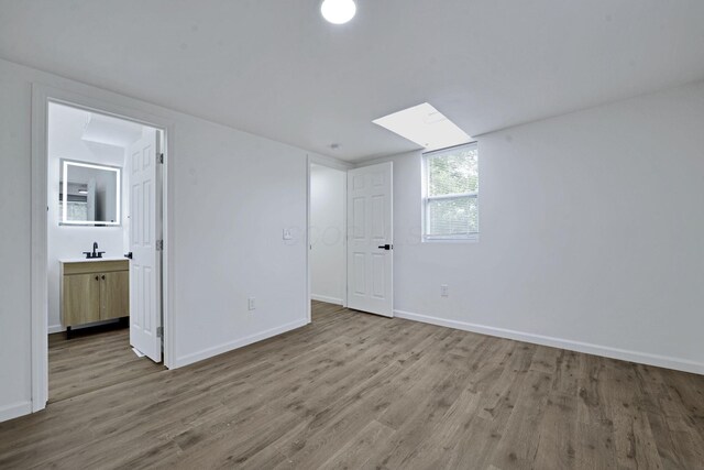 863 Carpenter St, Columbus, OH 43206 - unfurnished bedroom featuring wood finished floors, a skylight, and ensuite bathroom