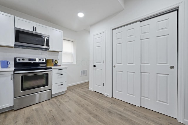 863 Carpenter St, Columbus, OH 43206 - kitchen featuring stainless steel appliances, white cabinets, light countertops, light wood finished floors, and recessed lighting