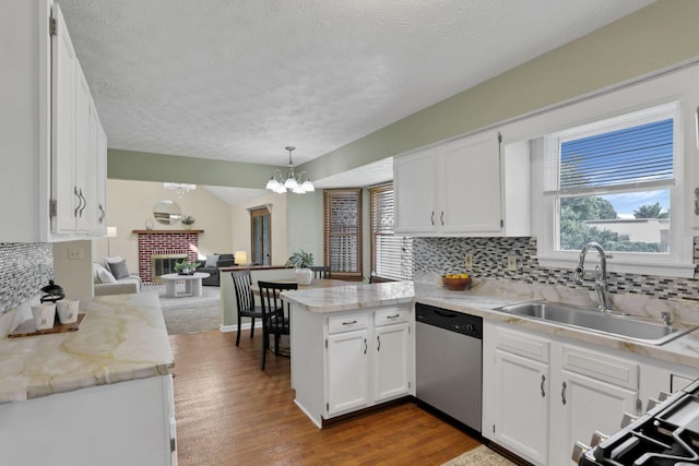 6464 Blackhaw Dr, Reynoldsburg, OH 43068 - kitchen with stainless steel dishwasher, a peninsula, backsplash, white cabinetry, and a textured ceiling