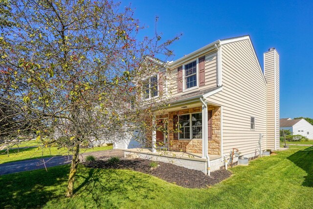 5700 Boucher Dr, Orient, OH 43146 - view of front facade featuring stone siding, a front yard, a chimney, a garage, and a porch