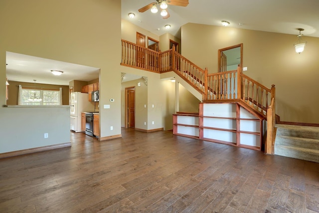 5700 Boucher Dr, Orient, OH 43146 - unfurnished living room with ceiling fan, stairs, dark wood-style floors, and vaulted ceiling
