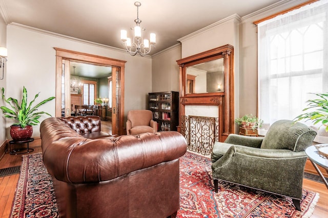 1412 Bryden Rd, Columbus, OH 43205 - living room with a chandelier, wood-type flooring, ornamental molding, and a fireplace