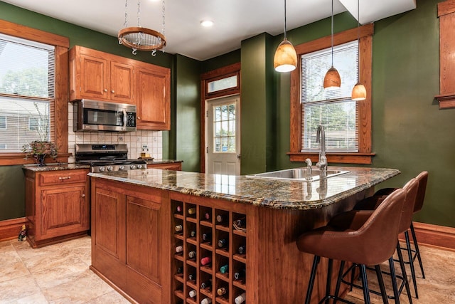 1412 Bryden Rd, Columbus, OH 43205 - kitchen featuring appliances with stainless steel finishes, dark stone countertops, plenty of natural light, a kitchen island, and recessed lighting