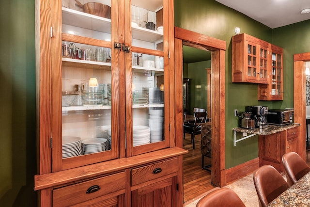 1412 Bryden Rd, Columbus, OH 43205 - kitchen featuring light wood-style floors, glass insert cabinets, and brown cabinetry