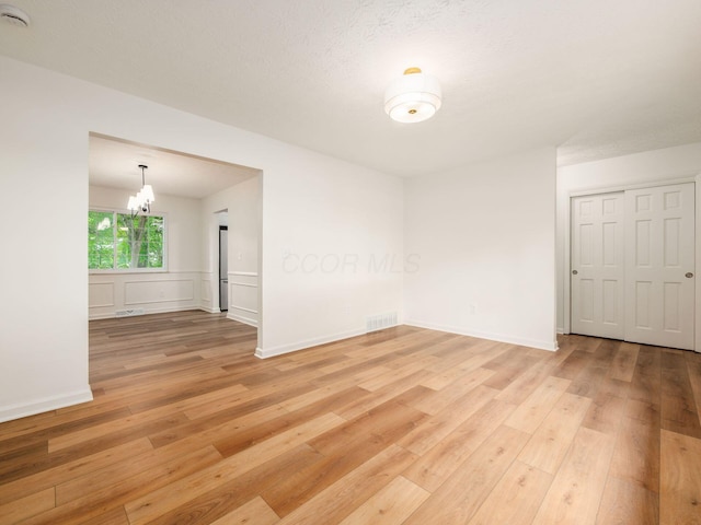 6019 Beechcroft Rd, Columbus, OH 43229 - unfurnished room with light wood finished floors, a chandelier, and a smoke detector