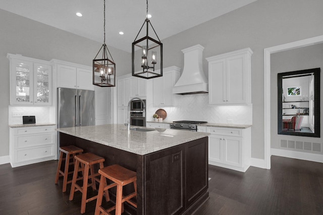 7211 Craigens Ct, Plain City, OH 43064 - kitchen with custom exhaust hood, appliances with stainless steel finishes, dark wood finished floors, tasteful backsplash, and a center island with sink