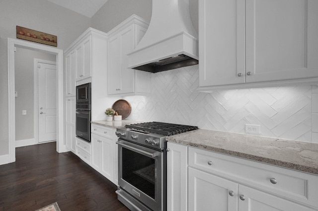 7211 Craigens Ct, Plain City, OH 43064 - kitchen featuring premium range hood, stainless steel stove, black oven, light stone countertops, and white cabinetry