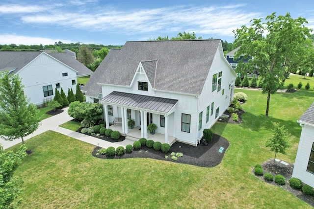 7211 Craigens Ct, Plain City, OH 43064 - modern farmhouse with a standing seam roof, a porch, a shingled roof, a front lawn, and a metal roof