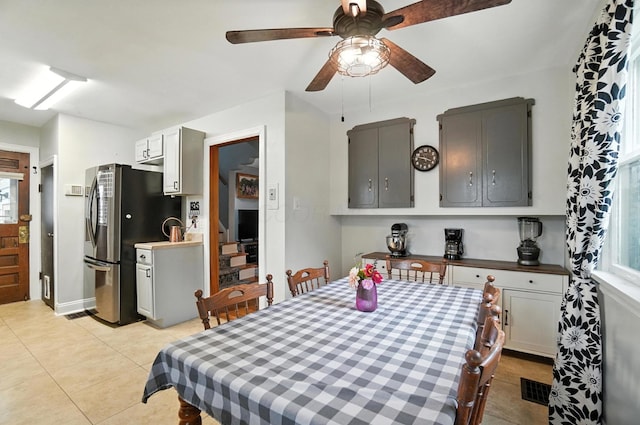 613 Salisbury Rd, Columbus, OH 43204 - dining area featuring ceiling fan, light tile patterned flooring, and stairs