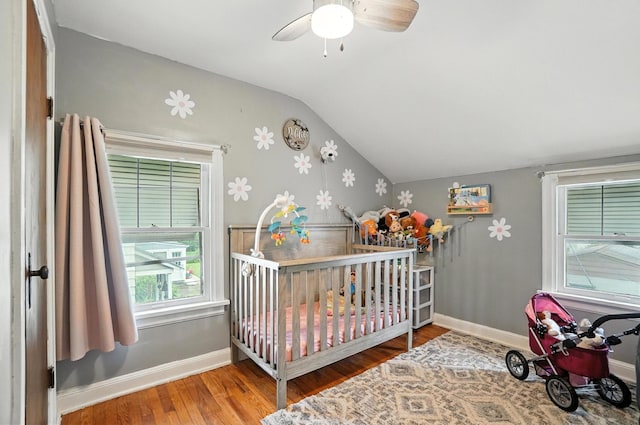 613 Salisbury Rd, Columbus, OH 43204 - bedroom with vaulted ceiling, wood finished floors, a crib, and a ceiling fan