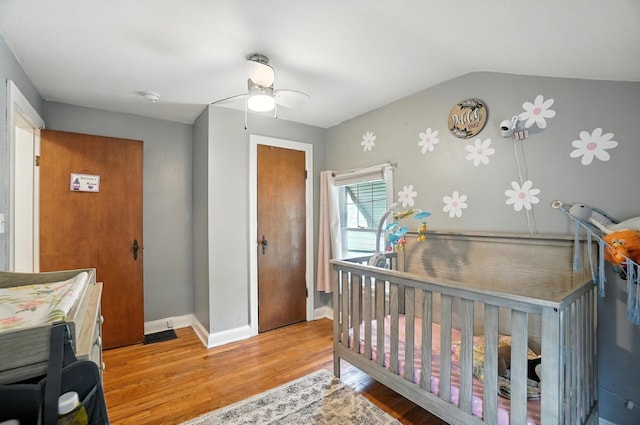 613 Salisbury Rd, Columbus, OH 43204 - bedroom with wood finished floors, lofted ceiling, ceiling fan, and a crib