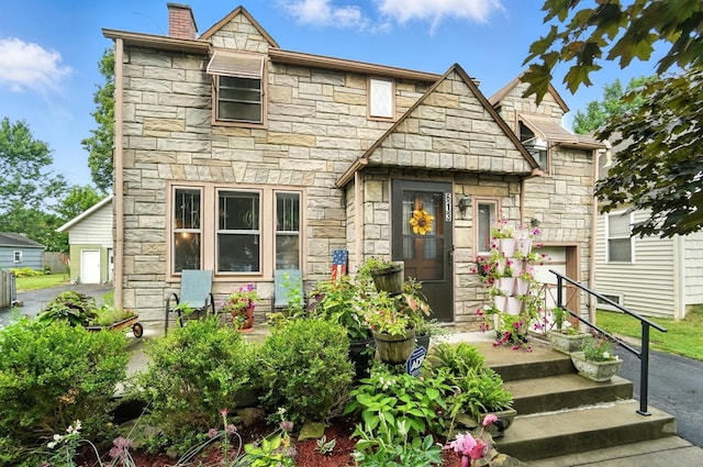 613 Salisbury Rd, Columbus, OH 43204 - view of front of home featuring stone siding, a chimney, and a garage