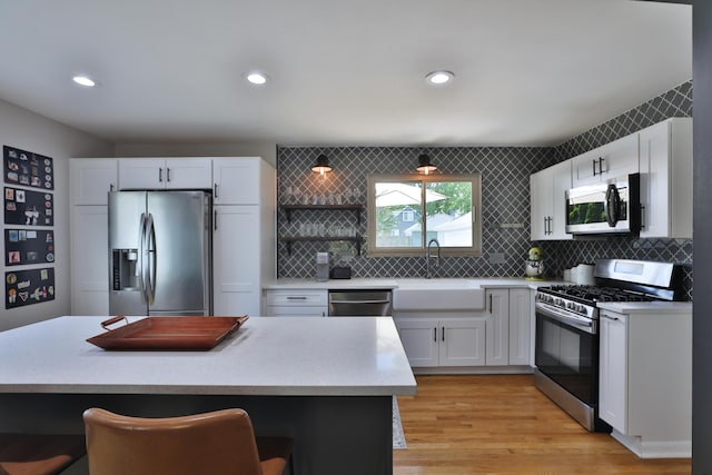 315 S Kellner Rd, Columbus, OH 43209 - kitchen featuring appliances with stainless steel finishes, a kitchen breakfast bar, light countertops, white cabinetry, and recessed lighting