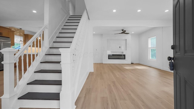 285 E Cherry St, Sunbury, OH 43074 - stairs featuring a glass covered fireplace, wood finished floors, recessed lighting, and ceiling fan