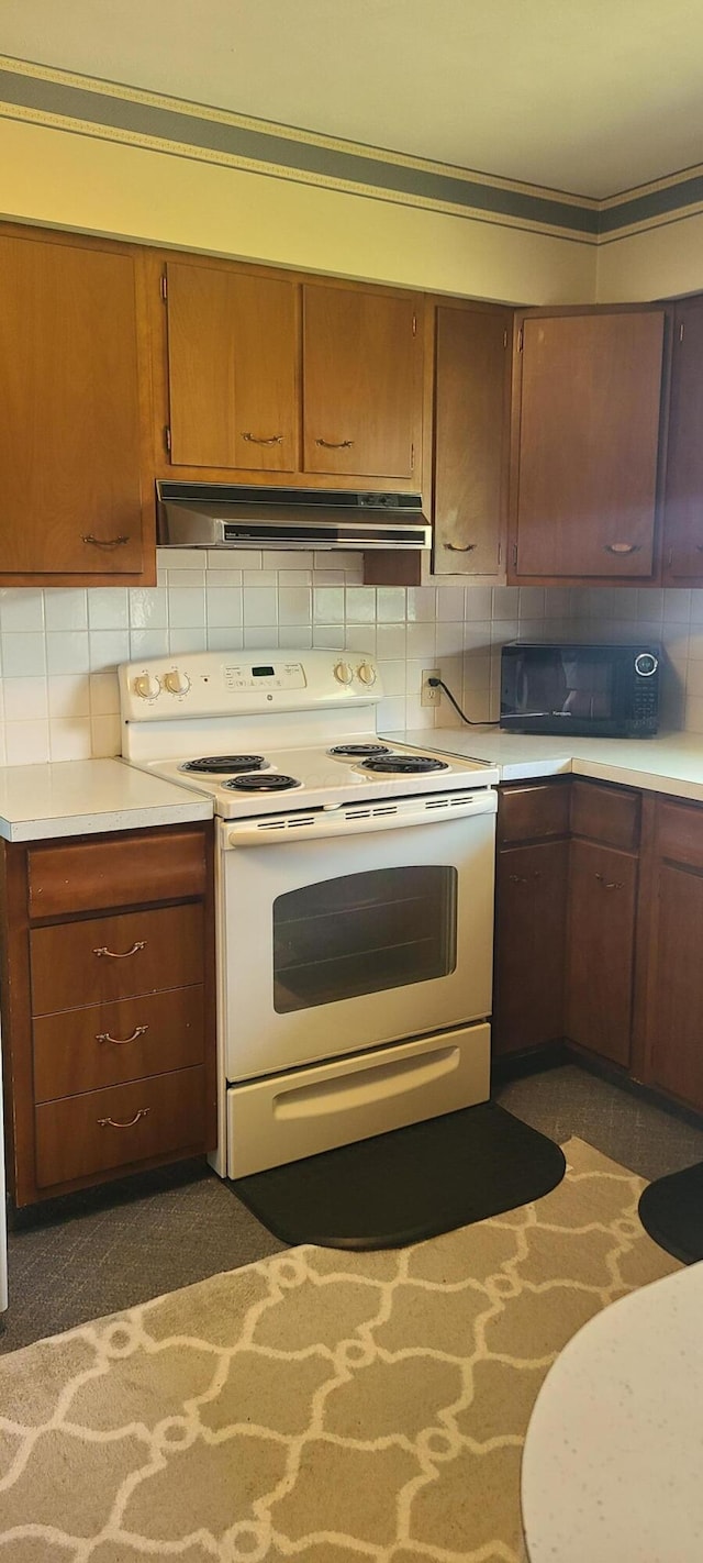 96 Summit St, Newark, OH 43055 - kitchen with electric range, black microwave, under cabinet range hood, light countertops, and tasteful backsplash