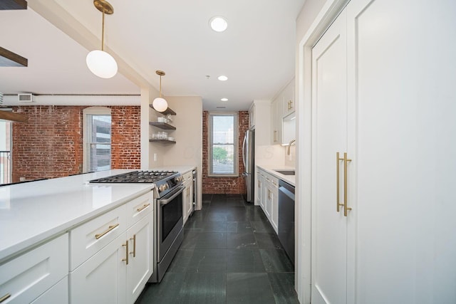 432 E Rich St Unit 3F, Columbus, OH 43215 - kitchen with stainless steel appliances, brick wall, white cabinets, pendant lighting, and light countertops