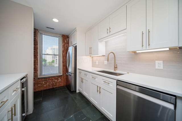 432 E Rich St Unit 3F, Columbus, OH 43215 - kitchen with appliances with stainless steel finishes, brick wall, light countertops, white cabinetry, and tasteful backsplash