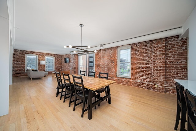 432 E Rich St Unit 3F, Columbus, OH 43215 - dining space featuring brick wall, light wood-style floors, and a chandelier