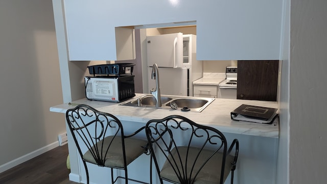 400 Forest Ln Unit 400, Richwood, OH 43344 - kitchen featuring white appliances, dark wood-type flooring, a kitchen breakfast bar, light countertops, and white cabinetry