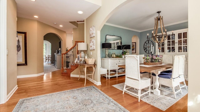 108 Hawks Cove Ct, Granville, OH 43023 - dining space featuring arched walkways, wood finished floors, stairs, a chandelier, and crown molding