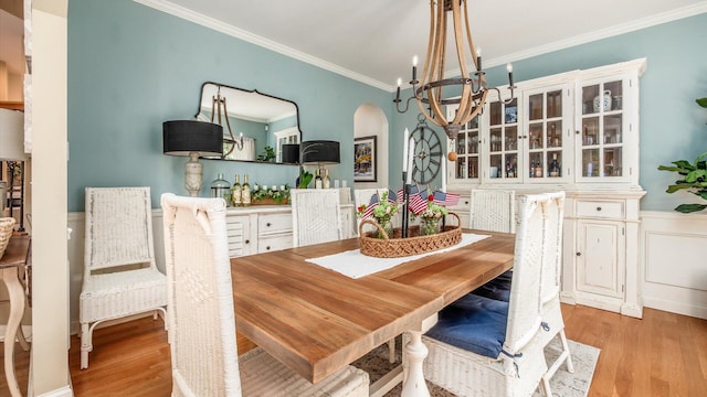 108 Hawks Cove Ct, Granville, OH 43023 - dining area featuring a chandelier, crown molding, light wood-style flooring, arched walkways, and wainscoting