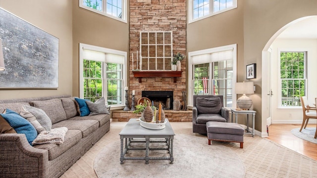 108 Hawks Cove Ct, Granville, OH 43023 - living area featuring healthy amount of natural light, arched walkways, a high ceiling, wood finished floors, and a fireplace