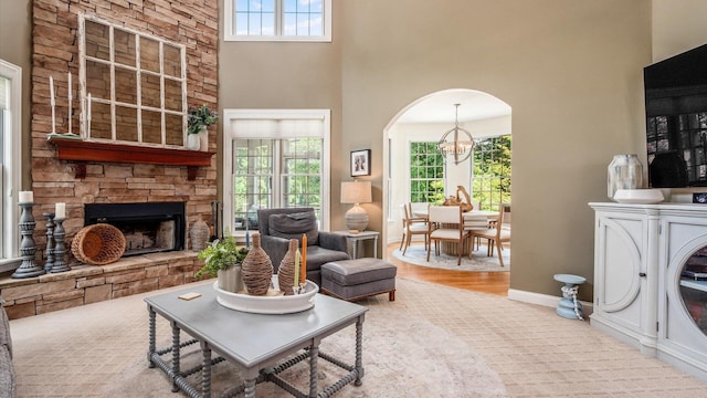 108 Hawks Cove Ct, Granville, OH 43023 - living area featuring a fireplace, arched walkways, healthy amount of natural light, a chandelier, and a high ceiling