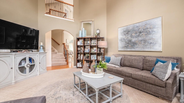 108 Hawks Cove Ct, Granville, OH 43023 - living room with arched walkways, stairway, a towering ceiling, and wood finished floors
