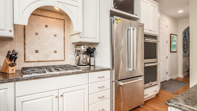 108 Hawks Cove Ct, Granville, OH 43023 - kitchen with stainless steel appliances, light wood finished floors, white cabinets, dark stone counters, and recessed lighting