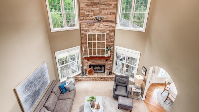 108 Hawks Cove Ct, Granville, OH 43023 - living room featuring a stone fireplace, healthy amount of natural light, arched walkways, a high ceiling, and a ceiling fan