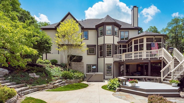 108 Hawks Cove Ct, Granville, OH 43023 - rear view of property featuring a sunroom, a deck, a chimney, a patio, and stairway