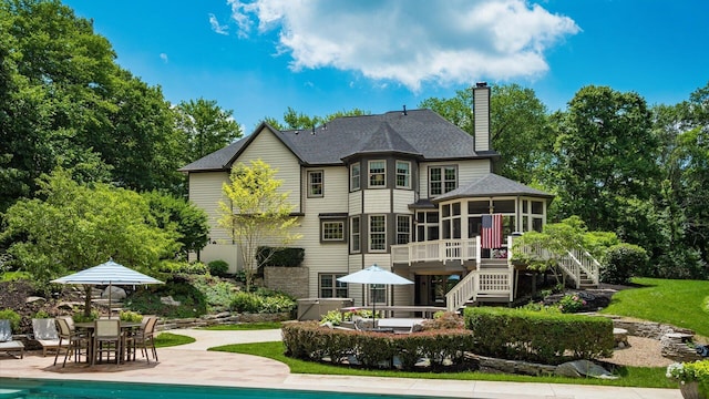 108 Hawks Cove Ct, Granville, OH 43023 - back of house with a sunroom, stairs, a patio, outdoor dining area, and a chimney