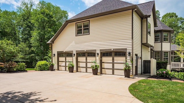 108 Hawks Cove Ct, Granville, OH 43023 - view of side of home featuring roof with shingles, an attached garage, and concrete driveway