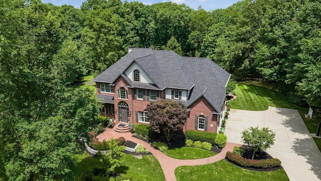 108 Hawks Cove Ct, Granville, OH 43023 - view of front of house featuring brick siding, concrete driveway, a front lawn, and a view of trees