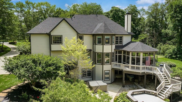 108 Hawks Cove Ct, Granville, OH 43023 - back of property with a sunroom, a chimney, a patio, a shingled roof, and stairway