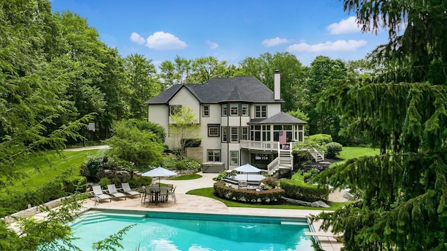 108 Hawks Cove Ct, Granville, OH 43023 - back of house featuring stairway, a patio, outdoor dining space, a sunroom, and a chimney