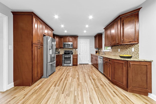 966 Larkstone Dr, Columbus, OH 43235 - kitchen with appliances with stainless steel finishes, light wood finished floors, light stone counters, backsplash, and recessed lighting